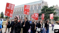 FILE - Protesters in Seattle, Washington, rally in support of raising the minimum wage to $15 an hour, April 1, 2015. 