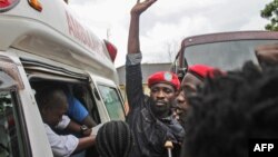 Le chanteur ougandais devenu politicien Robert Kyagulanyi, au centre, mieux connu sous le nom de Bobi Wine, monte dans une ambulance après sa libération sous caution à la Haute Cour de Gulu, dans le nord de l’Ouganda, le 27 août 2018.