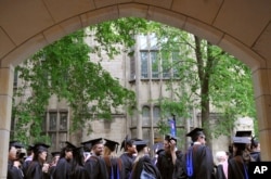 FILE - Future graduates wait for the procession to begin for commencement at Yale University in New Haven, Conn., May 24, 2010.