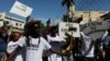 People march with signs reading "Down with false leaders", "Down with kidnappings" and "Down with the United States. 