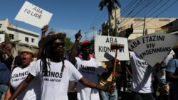 People march with signs reading "Down with false leaders", "Down with kidnappings" and "Down with the United States. 