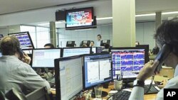 Brokers at a Lisbon trade room follow on video screens the Portuguese government bonds' auction, 12 Jan 2011