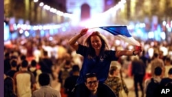 People celebrate on the Champs Elysees avenue, with the Arc de Triomphe in background, to celebrate after the semifinal match between France and Belgium at the 2018 soccer World Cup, Tuesday, July 10, 2018 in Paris, France. 