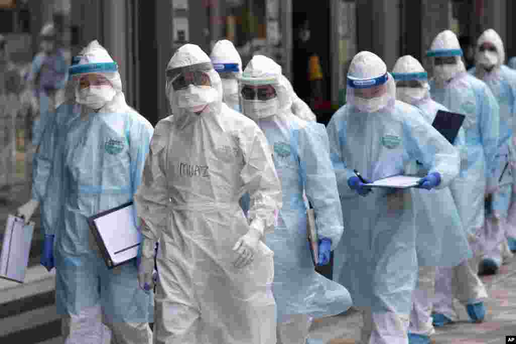 Medical workers in protective suits entering a building under lockdown in downtown Kuala Lumpur, Malaysia.