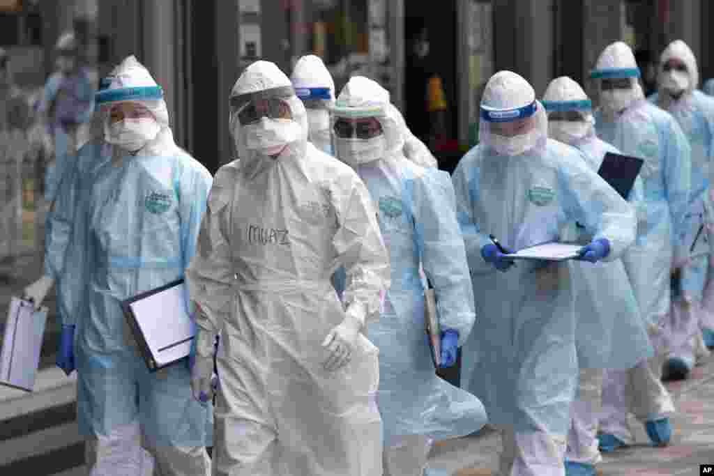 Medical workers in protective clothing enter a building under lockdown in downtown Kuala Lumpur, Malaysia.