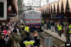 FILE - Refugees from Ukraine arrive to the railway station in Przemysl, Poland, Feb. 27, 2022.