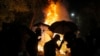 Students walk by a fire during a clash with police at the Chinese University in Hong Kong, Tuesday, Nov. 12, 2019. Police and protesters battled outside university campuses and several thousand demonstrators blocked roads as they took over a central…