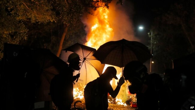 香港中文大学的学生在与警察的冲突中走过火堆。（2019年11月12日）