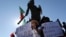 Demonstrators with signs that read in Spanish: "No more Caravans", and "Let's save Tijuana, no more caravans," stand under a statue of indigenous Aztec ruler Cuauhtemoc to protest the presence of thousands of Central American migrants in Tijuana, Mexico, Nov. 18, 2018.