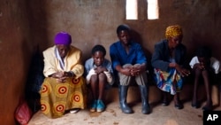 FILE - HIV-positive members of a self-help group pray at the start of a meeting in the village of Michelo, southern Zambia, Feb. 23, 2015.