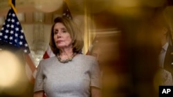 House Speaker Nancy Pelosi of California, accompanied by House Democratic members, listens to a reporter's question after signing a deal to reopen the government on Capitol Hill in Washington, Jan. 25, 2019.