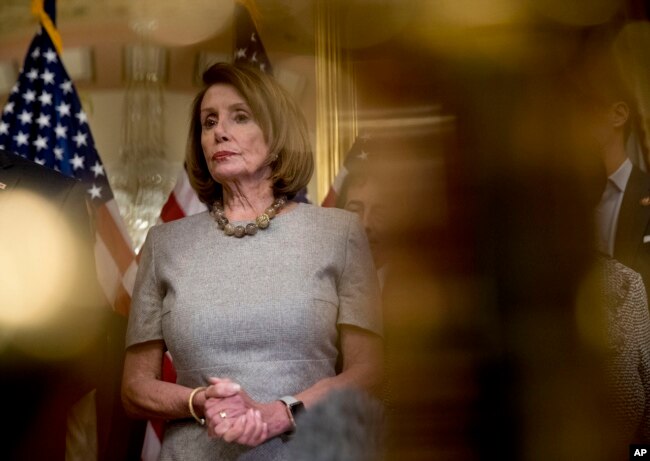 House Speaker Nancy Pelosi of California, accompanied by House Democratic members, listens to a reporter's question after signing a deal to reopen the government on Capitol Hill in Washington, Jan. 25, 2019.