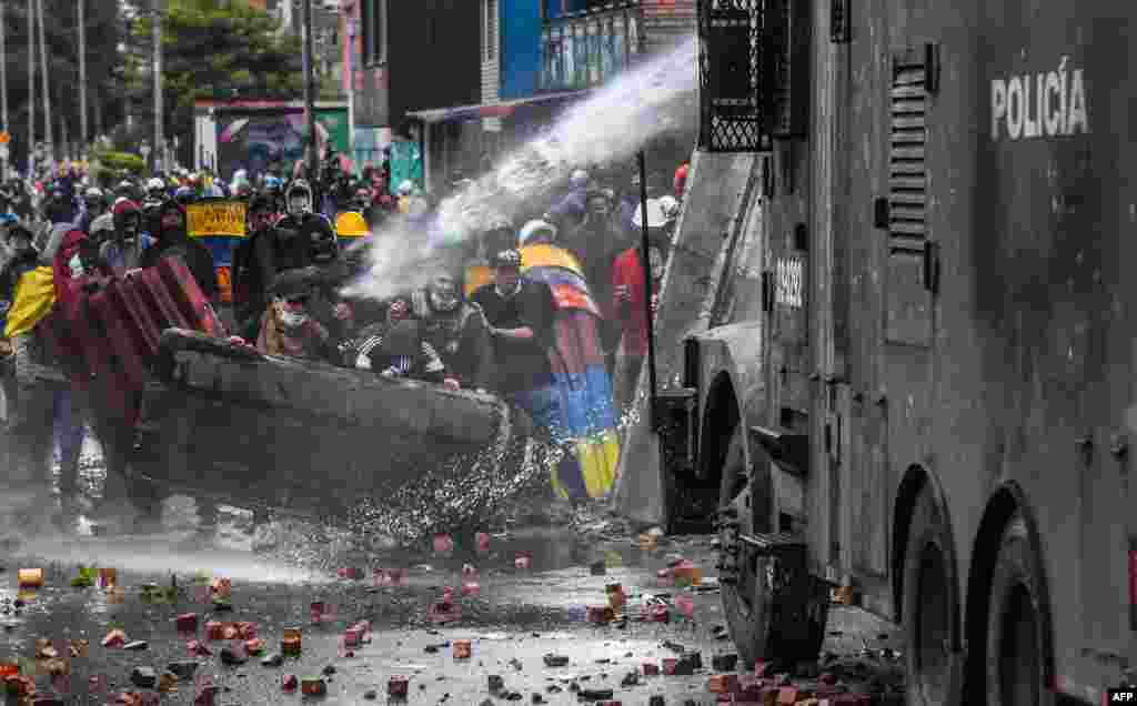 Police officers spray a water cannon at demonstrators during a protest of Colombian President Ivan Duque&#39;s government, in Bogota, June 9, 2021.