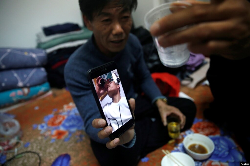 租住在北京郊区马驹桥小区的来京打工人王海洋（音）58岁，除夕夜和留京工友们一起吃年夜饭，还和儿子视频通话。（2021年2月11日）(photo:VOA)