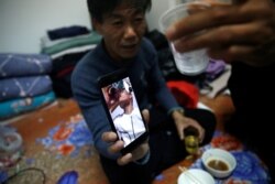 租住在北京郊區馬駒橋小區的來京打工人王海洋（音）58歲，除夕夜和留京工友們一起吃年夜飯，還和兒子視頻通話。 （2021年2月11日）
