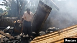 Seorang warga muslim Rohingya membersihkan reruntuhan Masjid di desa Thapyuchai, pinggiran kota Thandwe, yang dibakar warga Budha (3/10). 