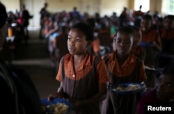 FILE - School children are served lunch at a primary school near Harare, Zimbabwe, Nov. 26, 2017.