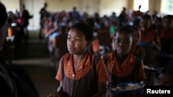 FILE - School children are served lunch at a primary school near Harare, Zimbabwe, Nov. 26, 2017.