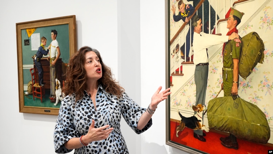 Heritage Auction's Aviva Lehmann shows paintings in Dallas, Texas, on Oct. 17, 2024, that are among works from the Boy Scouts of America's art collection that are going up for auction to help compensate tens of thousands of people who were sexually abused while in scouting.