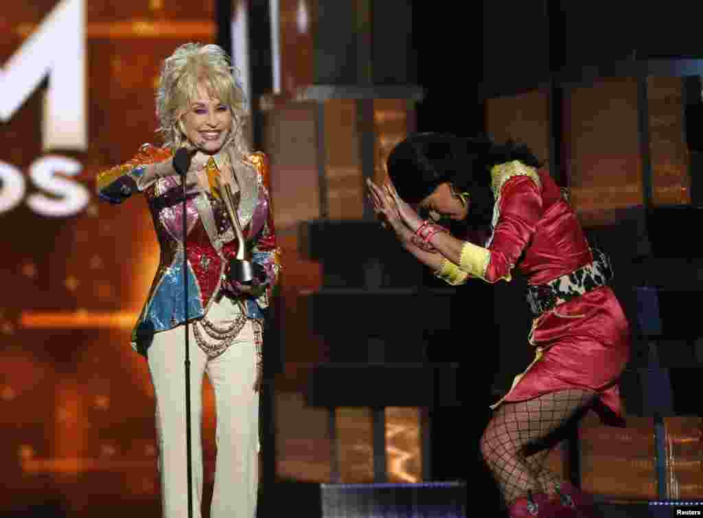 Dolly Parton accepts the Tex Ritter Award from presenter Katy Perry (R) at the 51st Academy of Country Music Awards in Las Vegas, Nevada, April 3, 2016.