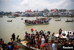 ဘင်္ဂလားဒေ့ရှ်နိုင်ငံ Dhaka မြို့ရှိ Buriganga မြစ်ထဲ နစ်မြုပ်ခဲ့တဲ့ ကူးတို့သင်္ဘာက သေဆုံးသွားသူတွေကို သယ်ဆောင်နေတဲ့ မြင်ကွင်း။ (ဇွန် ၂၉၊ ၂၀၂၀)