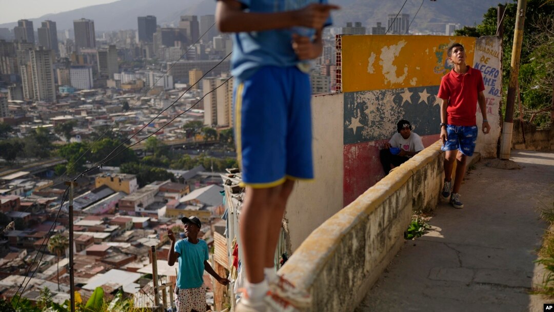 Jóvenes vuelan sus papalotes en el barrio San Agustín de Caracas, Venezuela, el lunes 3 de abril de 2023. (Foto AP/Matias Delacroix)