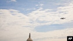 Phi thuyền Discovery bay ngang bầu trời thủ đô Washington, trong đó có Tượng đài Washington và tòa nhà Quốc hội Hoa Kỳ.