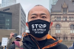 FILE - A man attends a protest against anti-Asian hate crimes, racism and vandalism, outside City Hall in Toronto, Ontario, Canada, March 28, 2021.