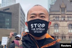 FILE - A man attends a protest against anti-Asian hate crimes, racism and vandalism, outside City Hall in Toronto, Ontario, Canada, March 28, 2021.