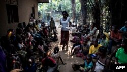 FILE - A volunteer brings daily food rations for internally displaced persons (IDPs), at a camp for IDPs fleeing the conflict in Congo's Kasai region, in Kikwit, DRC, June 7, 2017.