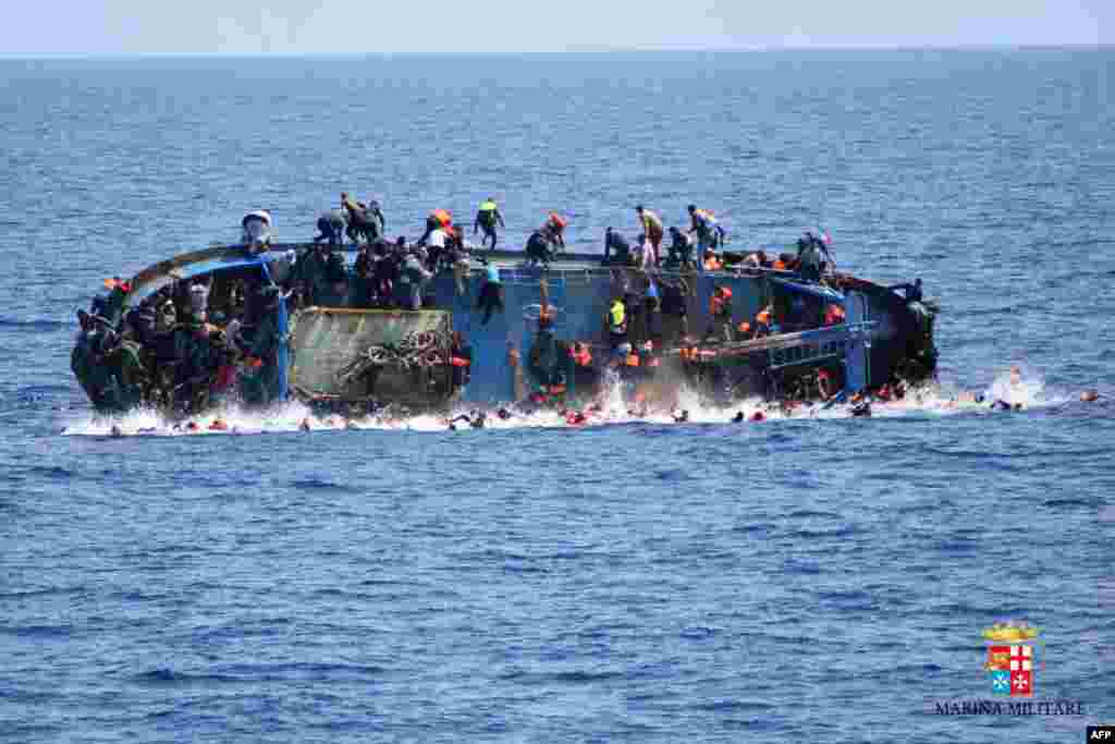 This handout picture by the Italian Navy (Marina Militare) shows the shipwreck of an overcrowded boat of migrants off the Libyan coast. At least seven migrants have drowned after the overcrowded boat overturned, the Italian Navy said. 500 people were pulled to safety but rescue operations were continuing and the death toll could rise, the navy said.