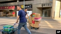工人们在香港一家公司门前走过，其地址为中资的“中国创新投资”。(2019年11月23日)