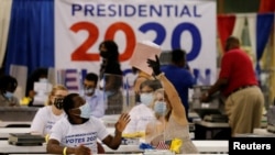 Les travailleurs électoraux ouvrent les bulletins de vote au bureau des élections du comté de Palm Beach lors de l'élection présidentielle américaine de 2020 à West Palm Beach, Floride, États-Unis, le 3 novembre 2020.