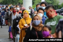 Penumpang yang mengenakan masker pelindung mengantre untuk uji antigen cepat di Bandara Soekarno Hatta, Tangerang, 22 Desember 2020. (Foto: Antara/Fauzan via Reuters)