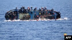 Ảnh của hải quân Italia ngày 25/5/2016 cho thấy một con tàu của di dân đang bị đắm ngoài khơi bờ biển Libya.