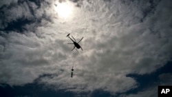 A helicopter from Whitefish Energy Holdings flies to power line towers for repairs after the passing of Hurricane Maria in Barceloneta, Puerto Rico, Oct. 15, 2017. 