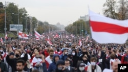 People with old Belarusian national flags march during an opposition rally to protest the official presidential election results in Minsk, Belarus, Sept. 27, 2020. 