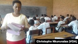 Une surveillante distribue les sujets aux élèves du au lycée du Lac Tanganyika qui passent leurs concours national, à Bujumbura, Burundi, le 21 juin 2017. (VOA/Christophe Nkurunziza)