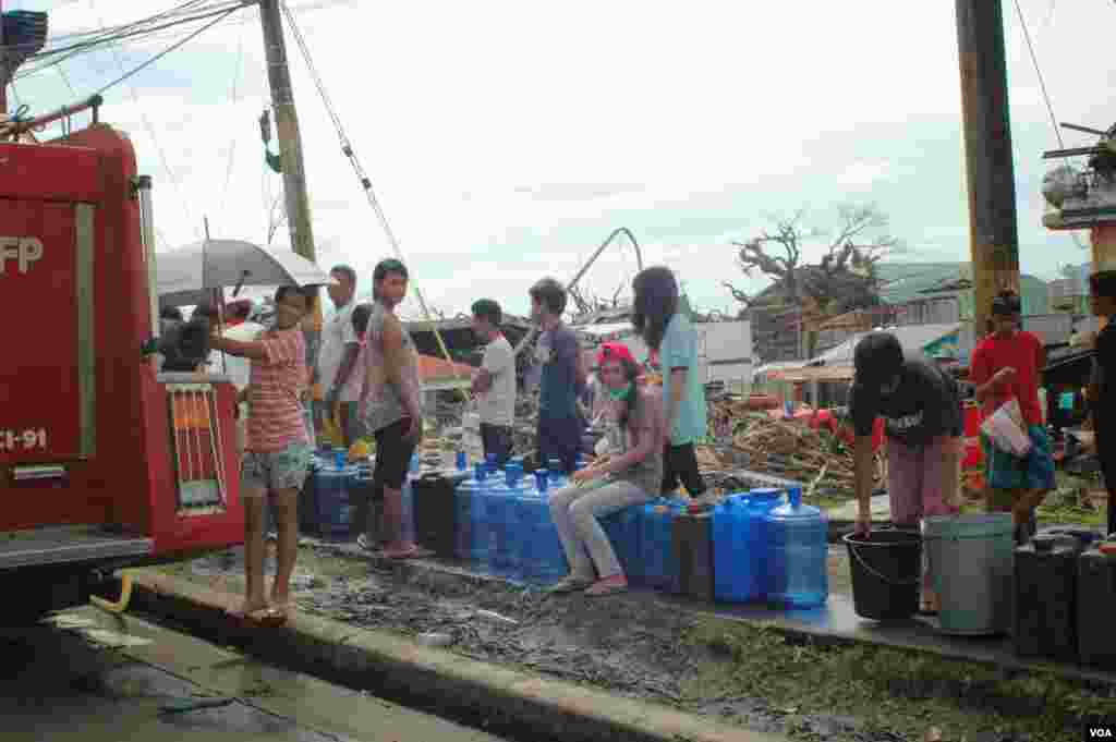 Survivors lining up to fill water containers near Tacloban City Hall, Nov. 21, 2013. (Steve Herman/VOA)