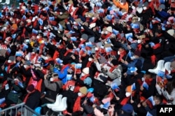 Spectators wave flags during the FIS Ski Cross World Cup 2022, part of a 2022 Beijing Winter Olympic Games test event at Genting Snow Park in Chongli county, Zhangjiakou city, China's Hebei province, Nov. 27, 2021.