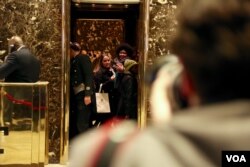 Two women smile at the press pool from the elevator at Trump Tower in New York, Dec. 12, 2016. (R. Taylor/VOA)