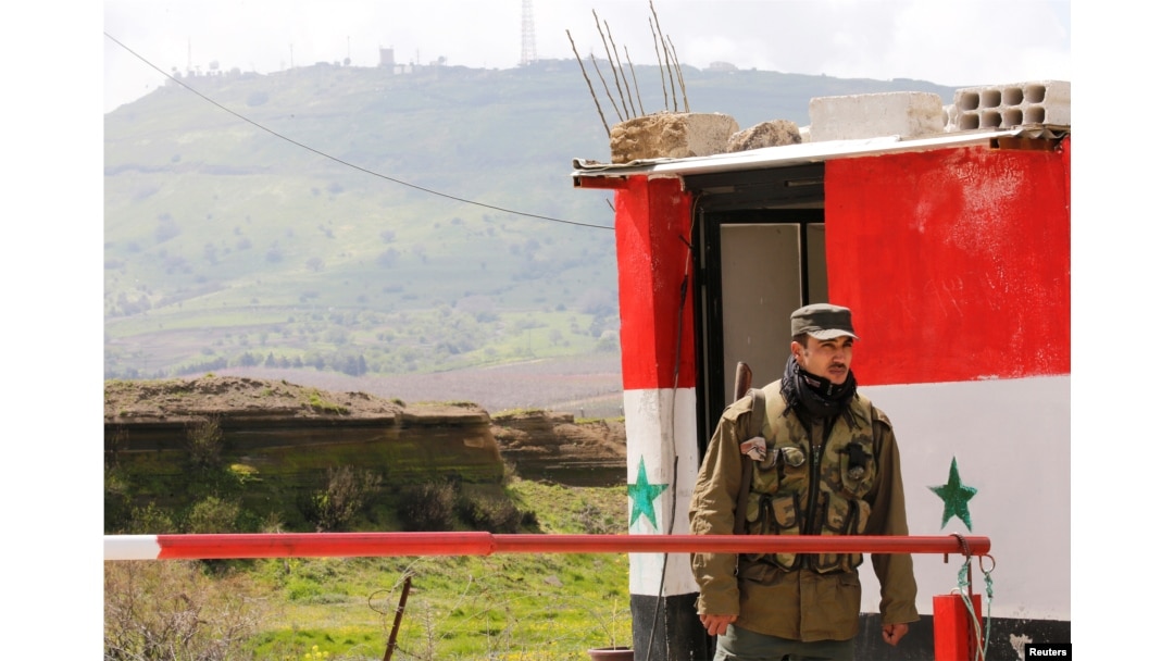 A Syrian army soldier stands at a checkpoint at the Quneitra crossing between the Israeli-controlled Golan Heights and Syria, seen from the Syrian side in Quneitra, Syria, March 26, 2019.