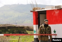 A Syrian army soldier stands at a checkpoint at the Quneitra crossing between the Israeli-controlled Golan Heights and Syria, seen from the Syrian side in Quneitra, Syria, March 26, 2019.