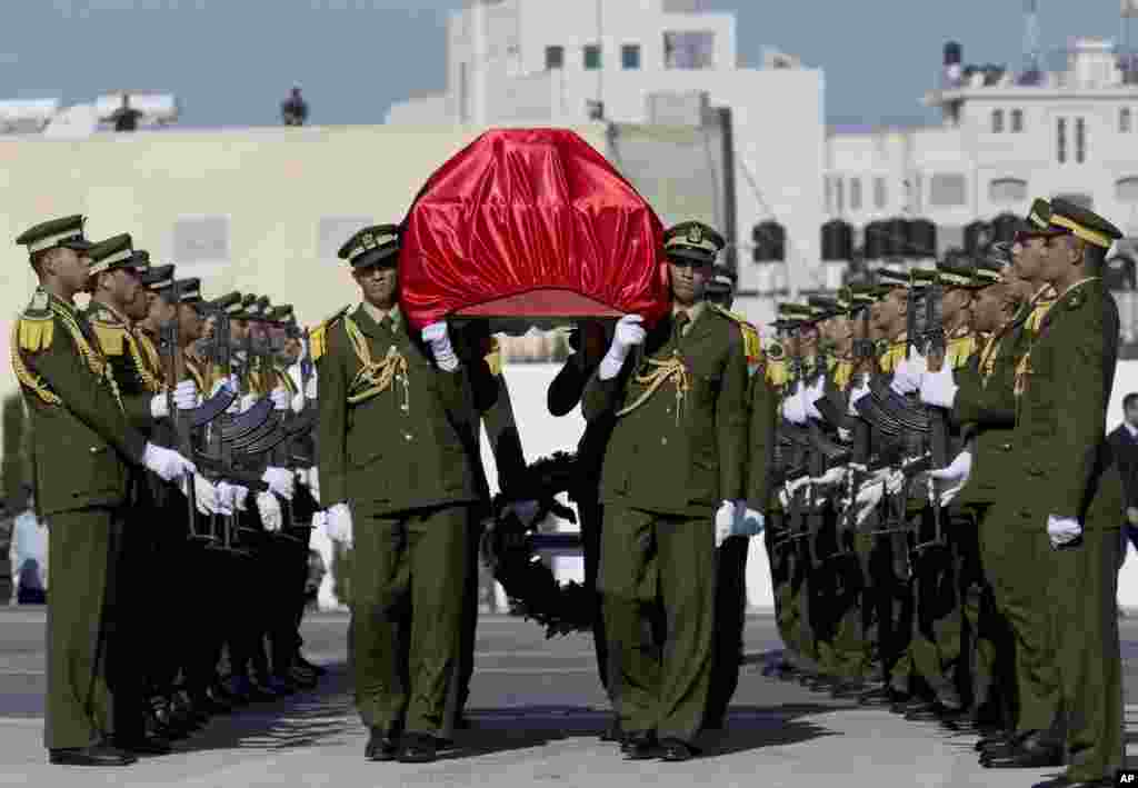 Palestinian honor guards carry the coffin of the late Palestinian Cabinet member Ziad Abu Ein during his funeral procession at the Palestinian Authority headquarters in the West Bank city of Ramallah, Dec. 11, 2014.