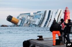 FILE - The cruise ship Costa Concordia lays on its side off the tiny Tuscan island of Giglio, Italy, Jan. 18, 2012.