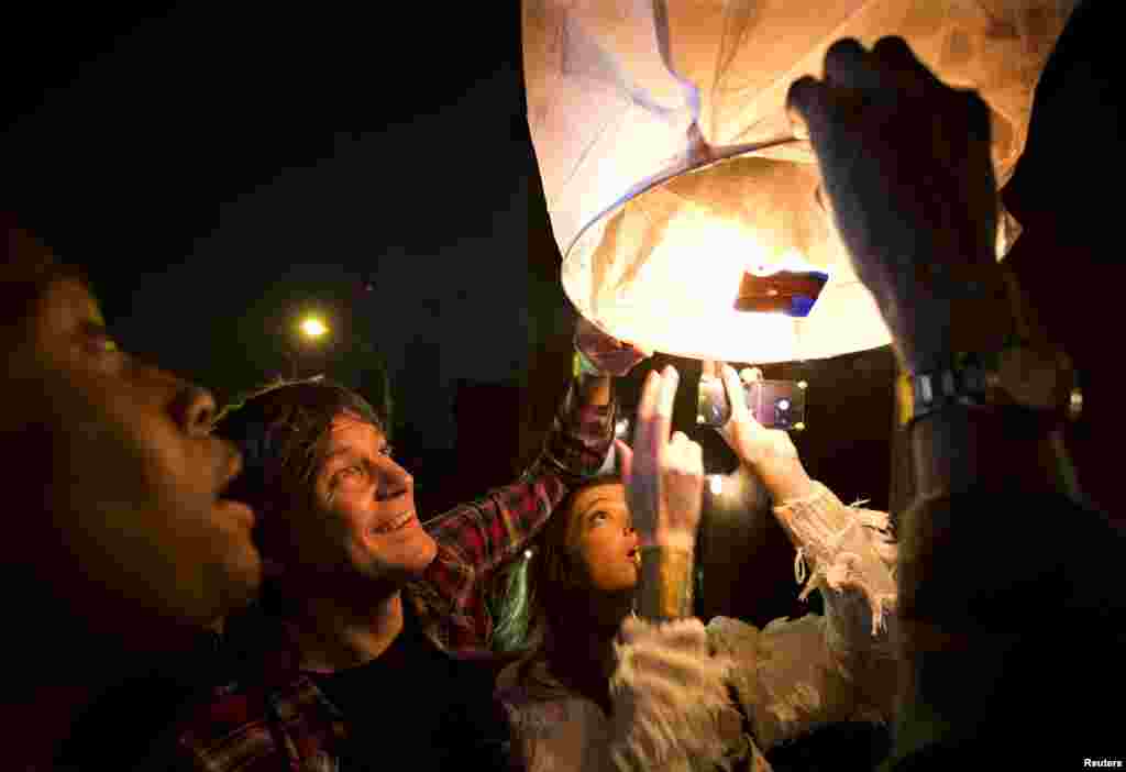People release paper lanterns after lighting them outside Madiba, a restaurant named in honor of Nelson Mandela, in the Brooklyn borough of New York, Dec. 5, 2013. 