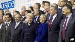 US Secretary of State Hillary Rodham Clinton, center, is flanked by Lithuania's FM Audronius Azubalis, right, and Lithuania's President Dalia Grybauskaite, left, as they attend an international conference of the Organization for Security and Cooperation i
