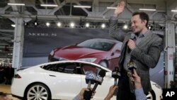 Izvršni direktor kompanije "Tesla" Elon Mask maše tokom skupa u fabrici tih vozila u Fremontu u Kaliforniji (AP Photo/Paul Sakuma)