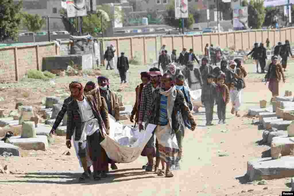 The bodies of victims of airstrikes are carried by relatives at a detention center prior to burial at a nearby cemetery, in Saada, Yemen, Jan. 25, 2022.