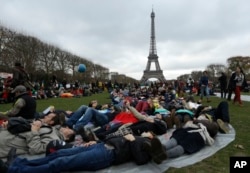 Activists stage a die in during a demonstration near the Eiffel Tower in Paris during the COP21, the United Nations Climate Change Conference, Dec.12, 2015.